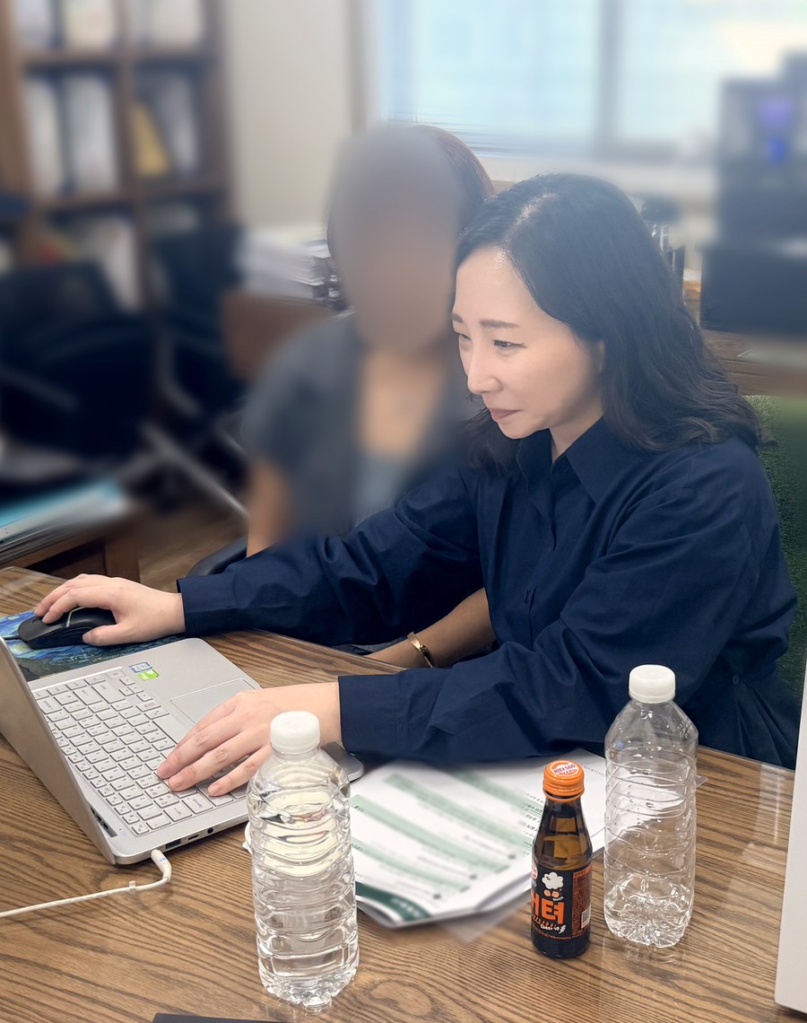 옆 사람과 함께 노트북 화면을 보며 작업하는 이청안